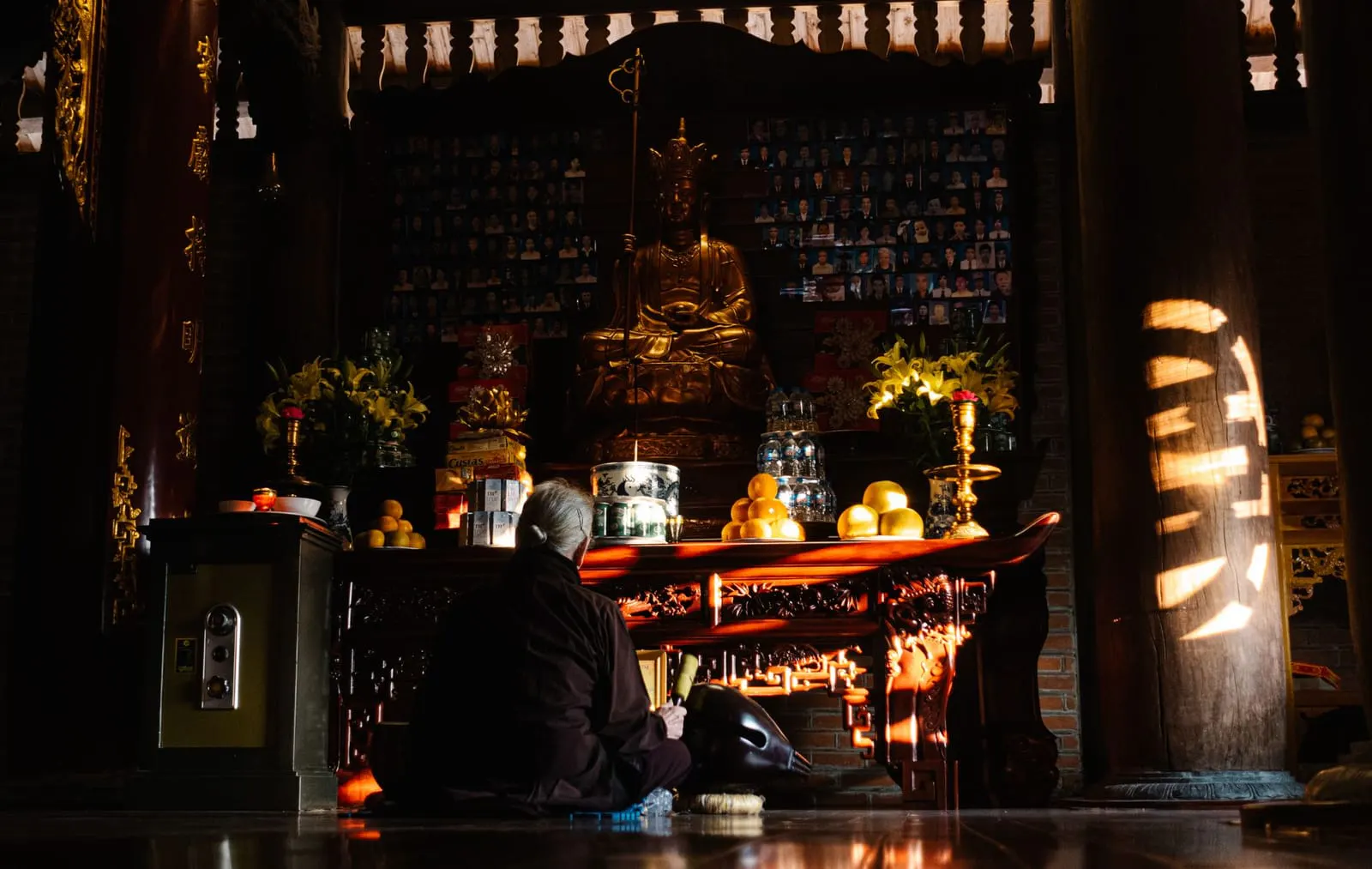 โต๊ะหมู่บูชาพระพุทธรูปตกแต่งด้วยดอกไม้และเครื่องบูชาในบ้าน