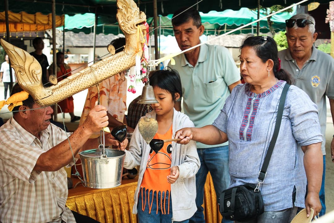 ผู้ใหญ่ยกมือให้พรลูกหลานที่กำลังนั่งพนมมือถามอยู่ตรงหน้า