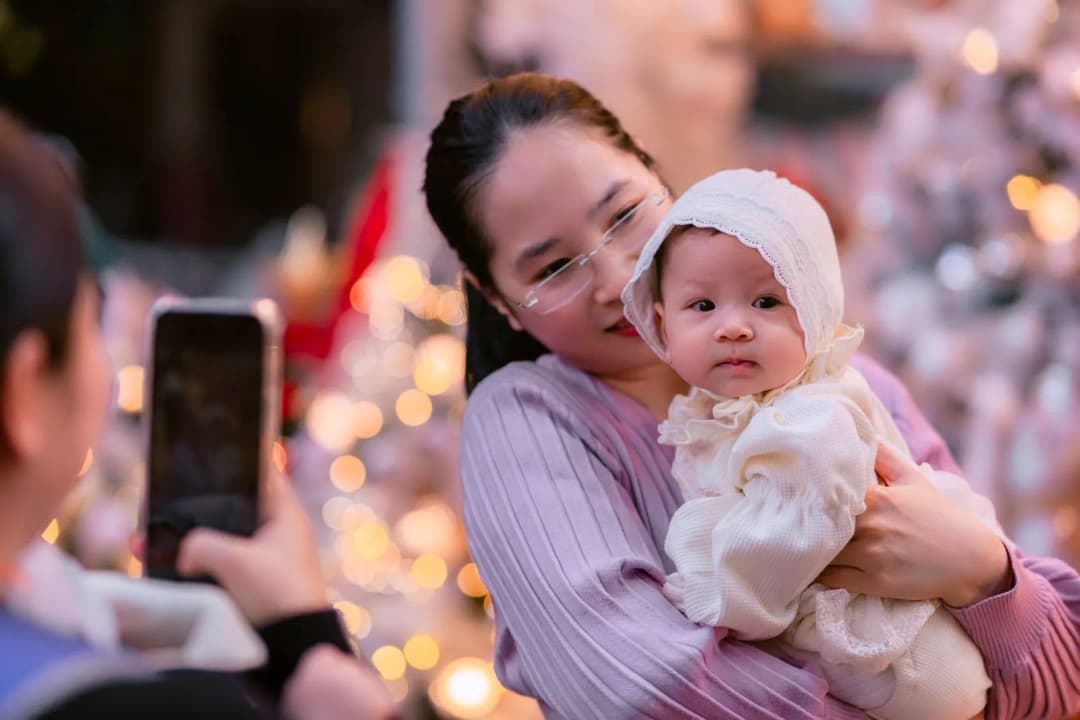 พ่อแม่ชาวไทยอุ้มลูกสาวแรกเกิดยิ้มอย่างมีความสุข