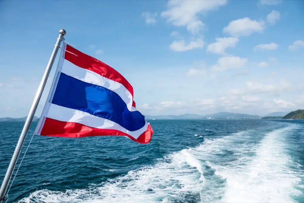 ธงชาติไทยและปฏิทินวางอยู่บนโต๊ะพร้อมเทียนวันเกิด