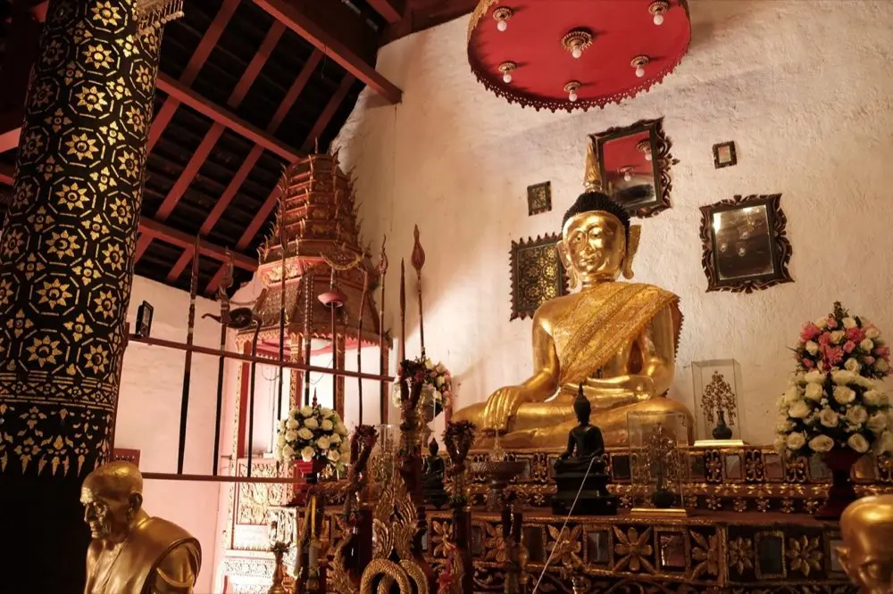 โต๊ะไหว้พระถือดอกไม้ธูปเทียนที่วัดในวันพระ