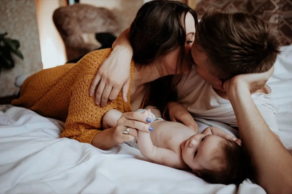 พ่อแม่อุ้มลูกน้อยในห้องนอนเด็กยามเช้า