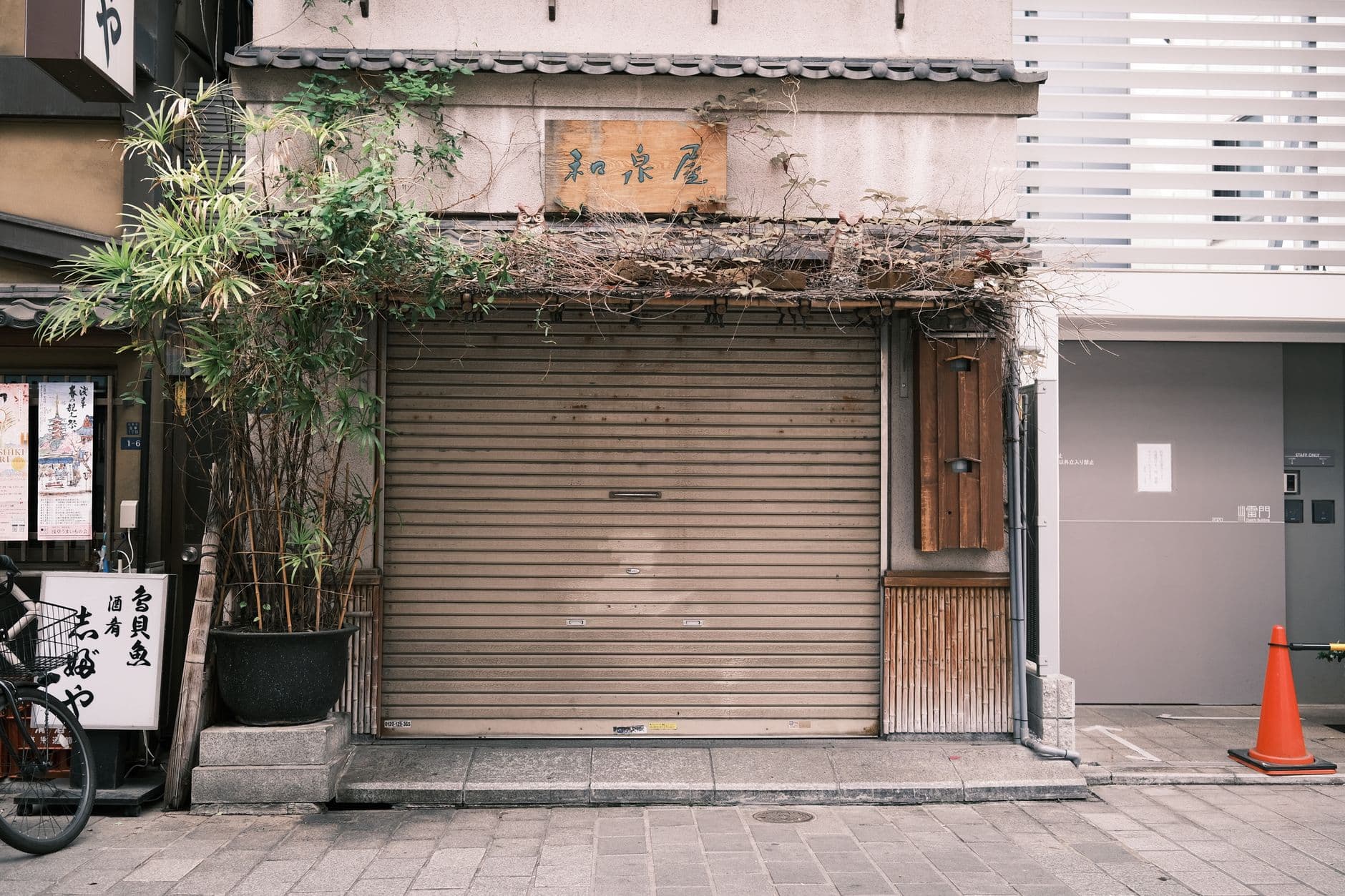 ป้ายปิดร้านถาวรติดอยู่หน้าประตูม้วนร้านค้าที่ปิดกิจการแล้ว