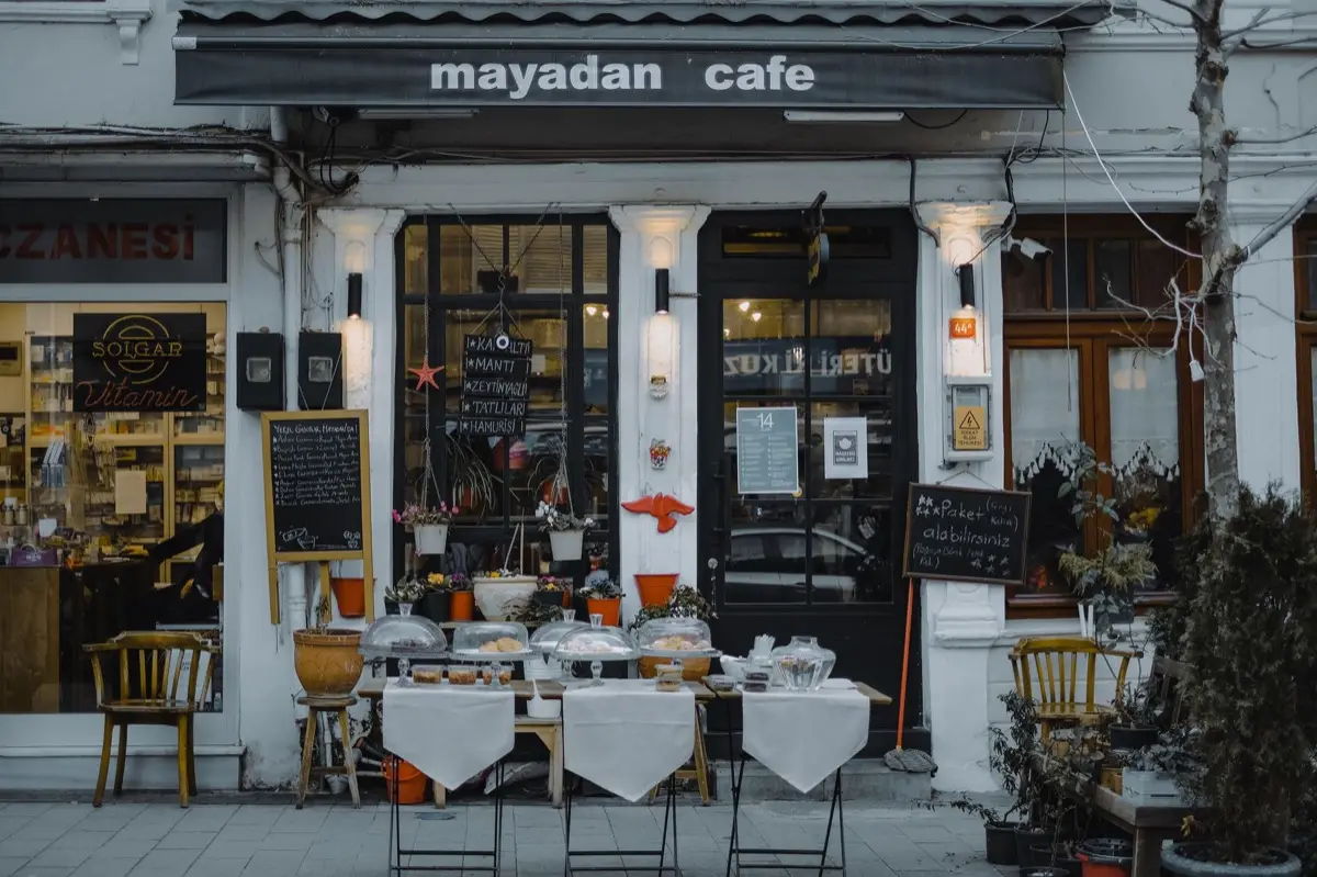 เจ้าของร้านยืนหน้าป้ายร้านค้าที่มีชื่อจดทะเบียนต่างจากชื่อที่ลูกค้าเรียกกันจริง