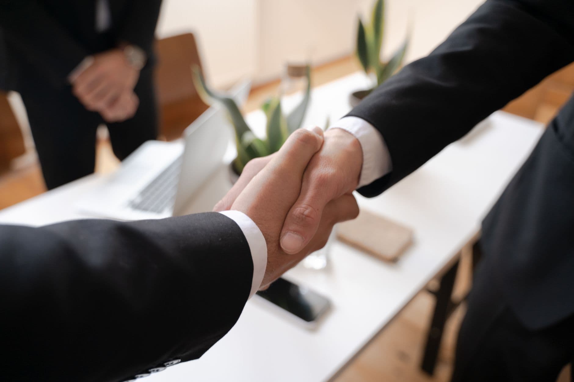 สองฝ่ายจับมือกันหลังจบการเจรจาธุรกิจในห้องประชุม