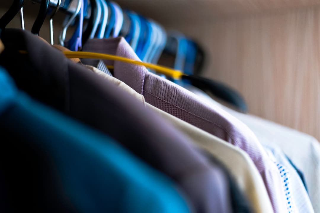 เสื้อผ้าหลากสีแขวนเรียงกันบนราวในร้าน