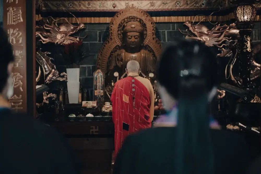คนสวดมนต์ไหว้พระที่โต๊ะพระในบ้านตอนเช้า
