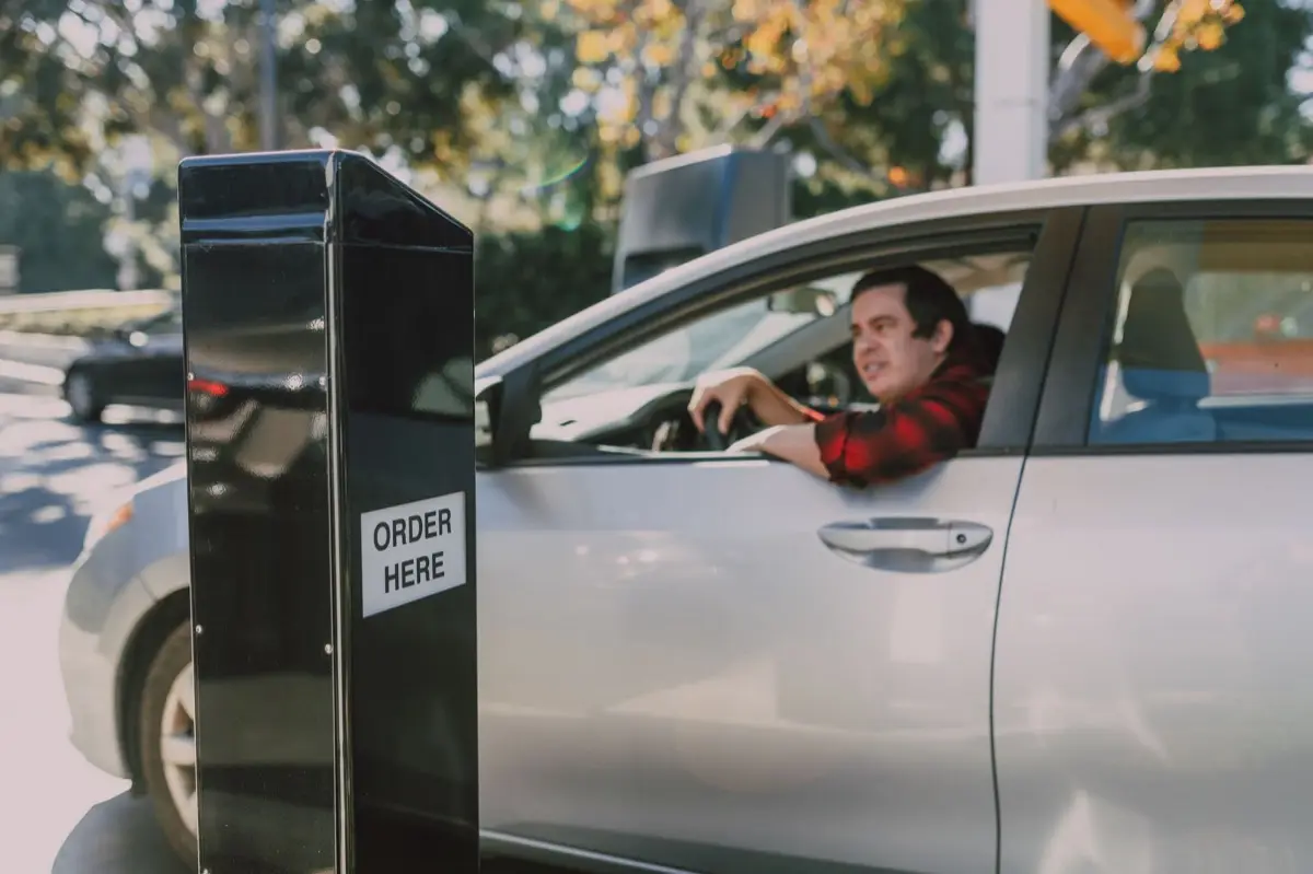 ช่องรับสินค้าแบบ drive-thru ของร้านอาหารพร้อมรถลูกค้าจอดรอ