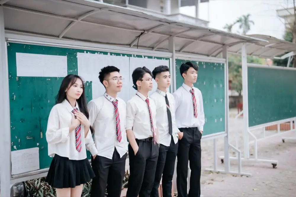 ชุดยูนิฟอร์มนักเรียนพร้อมเครื่องประดับชิ้นเล็กวางอยู่ข้างกัน