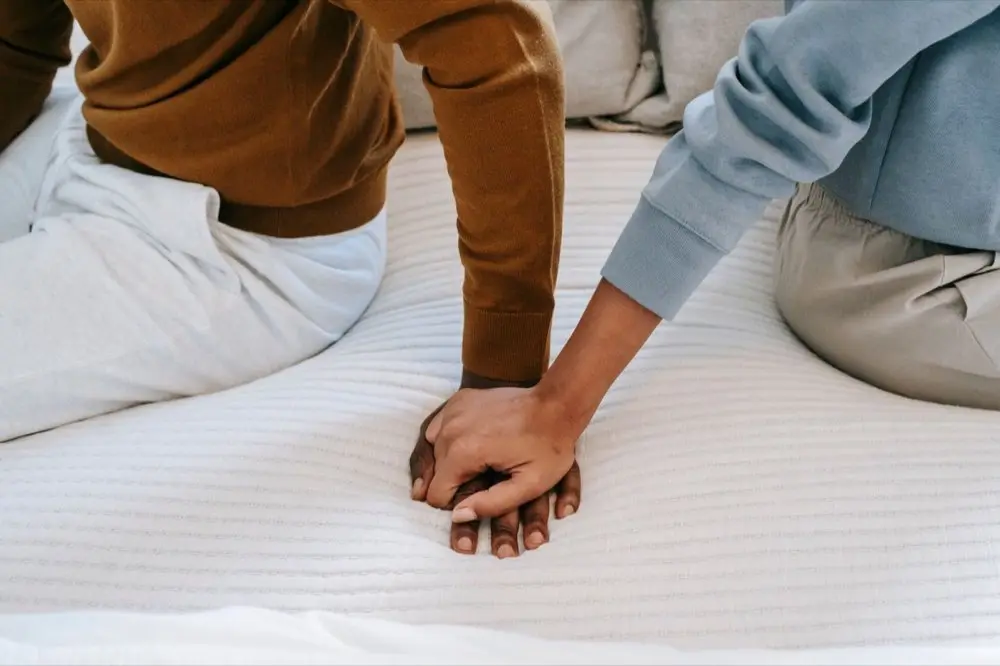 คู่รักต่างชาติจับมือกันยืนคุยกันในสวนสาธารณะ