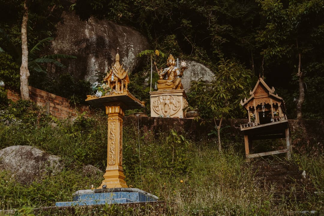 ผลไม้และดอกไม้จัดวางเป็นของไหว้หน้าศาลเทพไทย สื่อถึงของไหว้พื้นฐานที่ใช้บูชาครุฑ