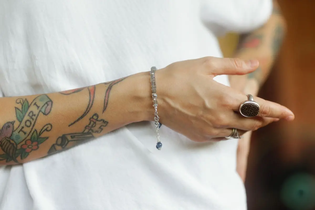 แหวนและสร้อยข้อมือหินมงคลดีไซน์เรียบสำหรับผู้ชายวางบนพื้นผิวไม้
