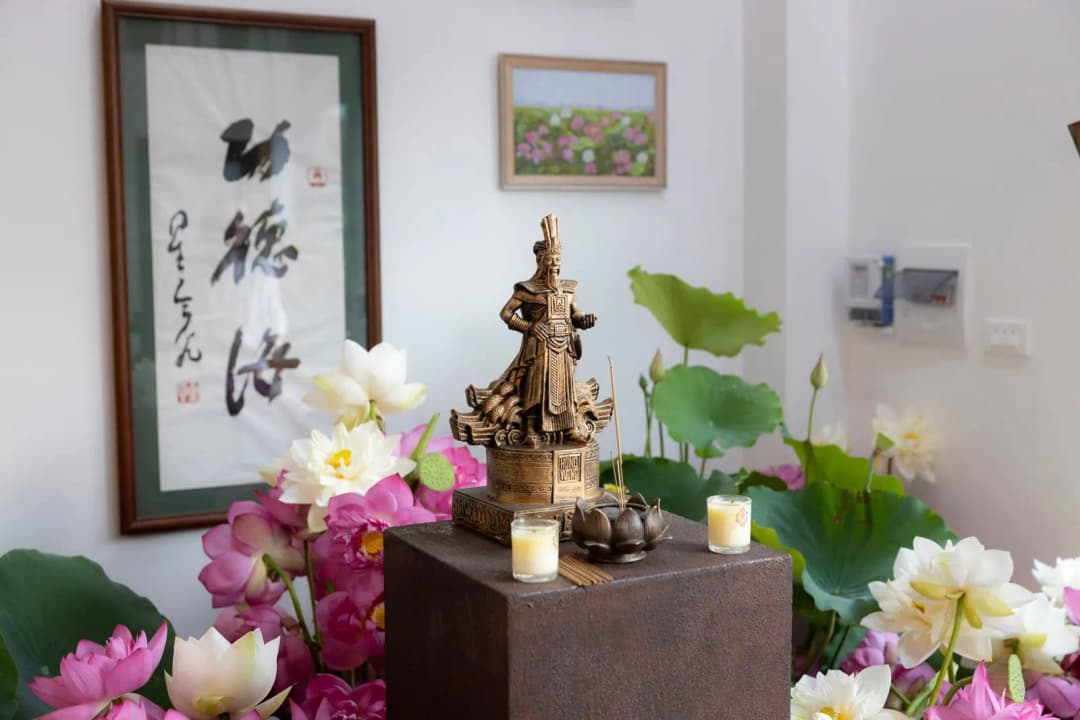 โต๊ะหมู่บูชาพระพุทธรูปในบ้าน มีธูปเทียนจุดอยู่