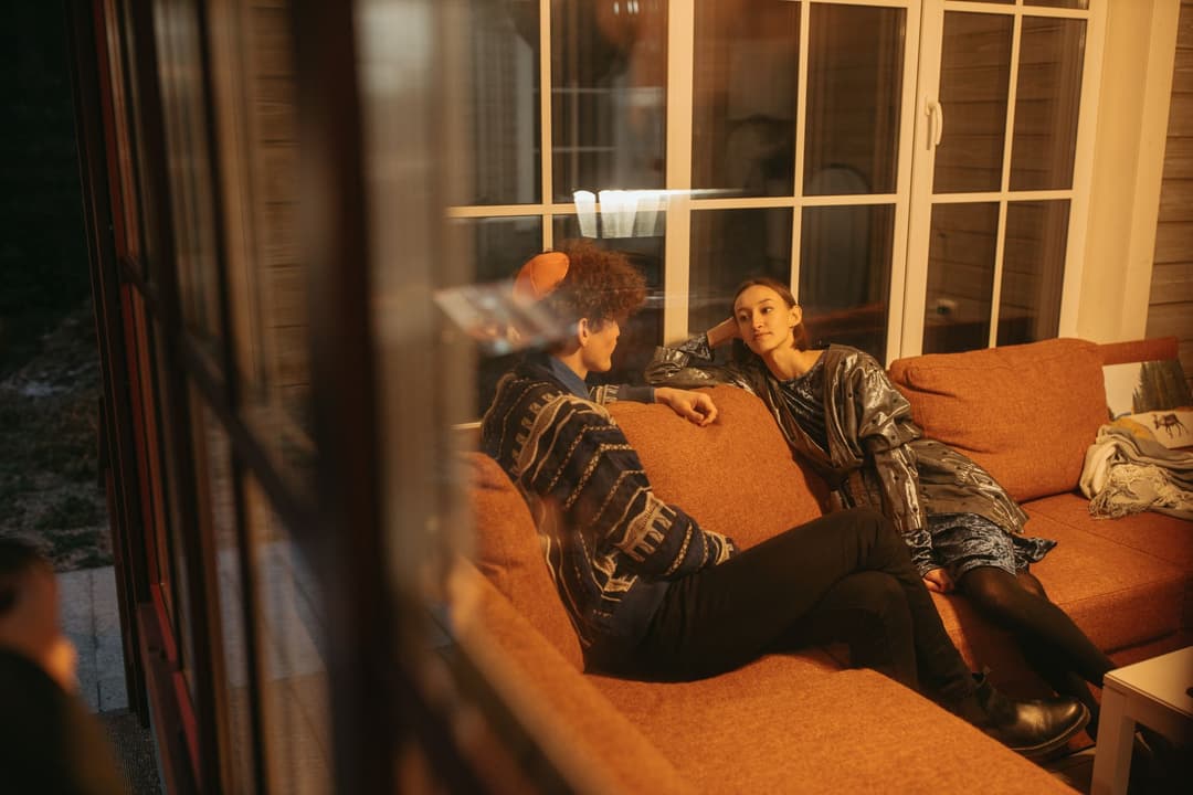 คู่รักคุยกันอย่างอบอุ่นในห้องนั่งเล่นที่บ้าน