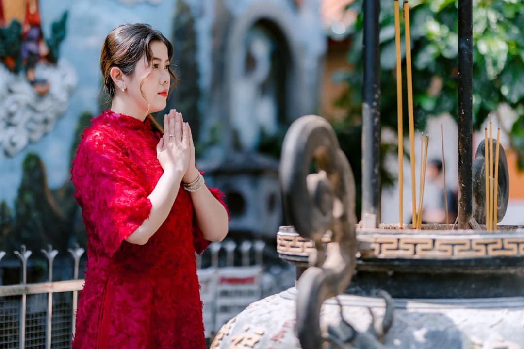 มือประนมไหว้พระพร้อมธูปควันในวิหารวัดไทย