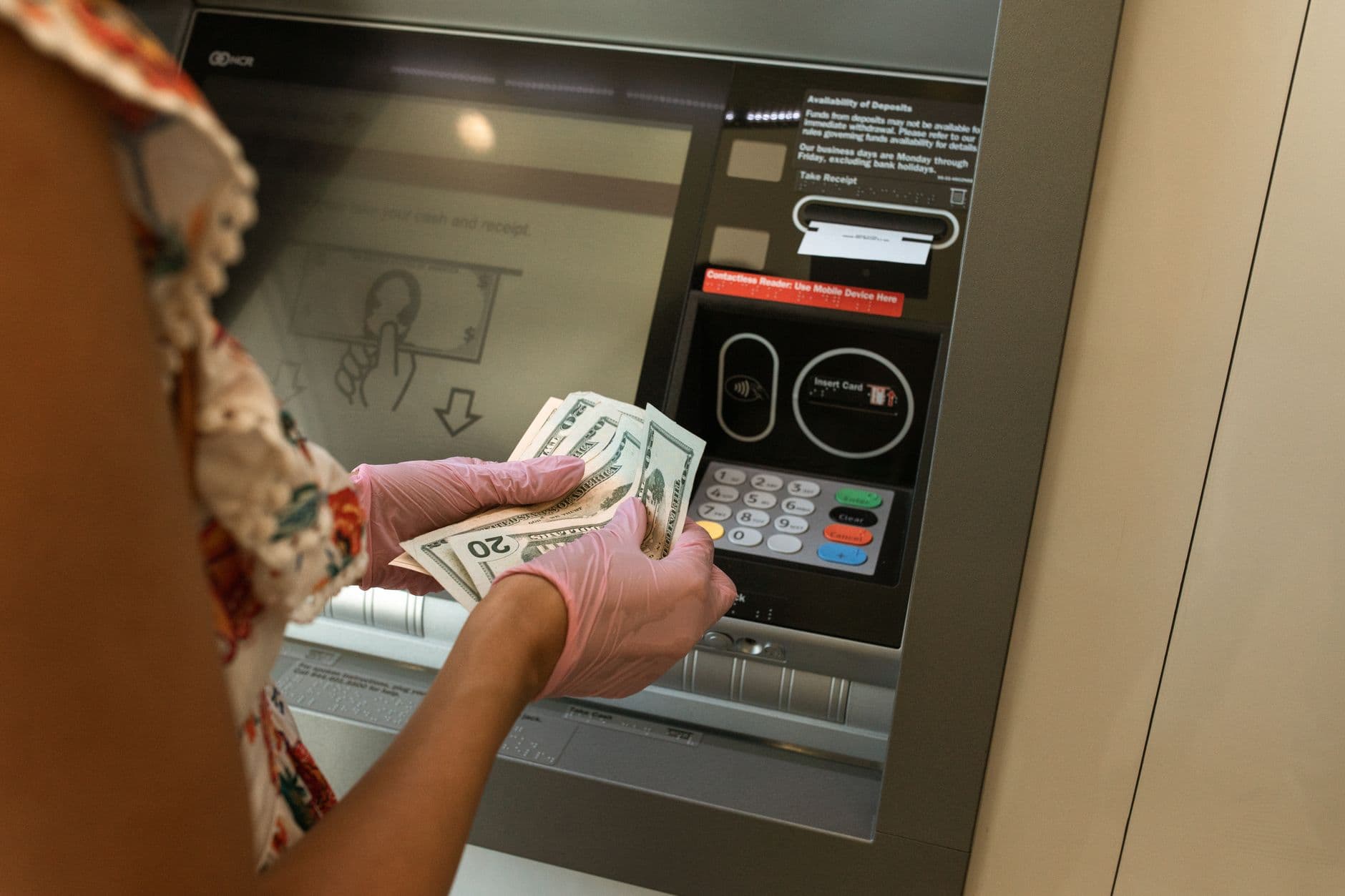 มือถือธนบัตรและสมุดบัญชีธนาคารบนโต๊ะขณะเปิดบัญชีใหม่