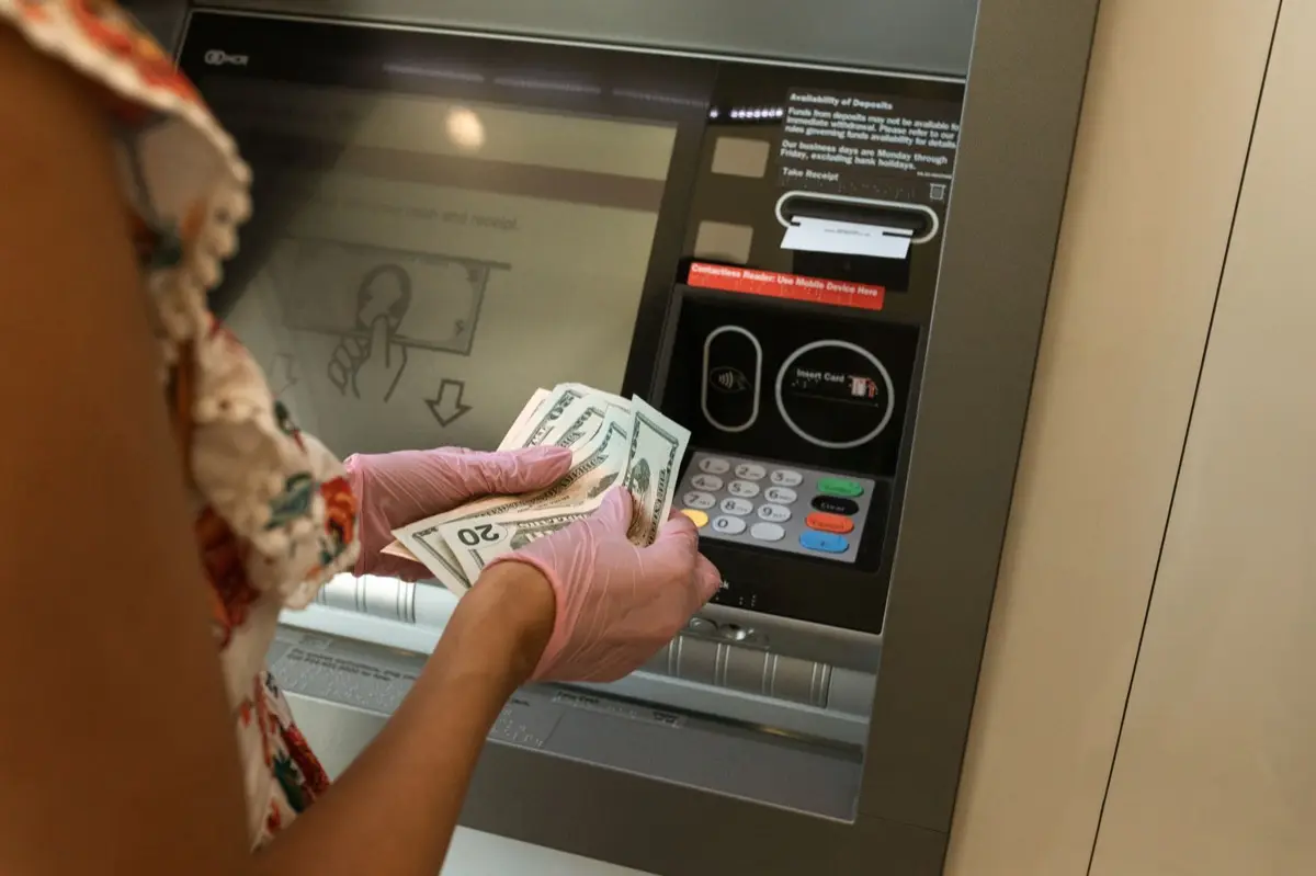 มือถือธนบัตรและสมุดบัญชีธนาคารบนโต๊ะขณะเปิดบัญชีใหม่