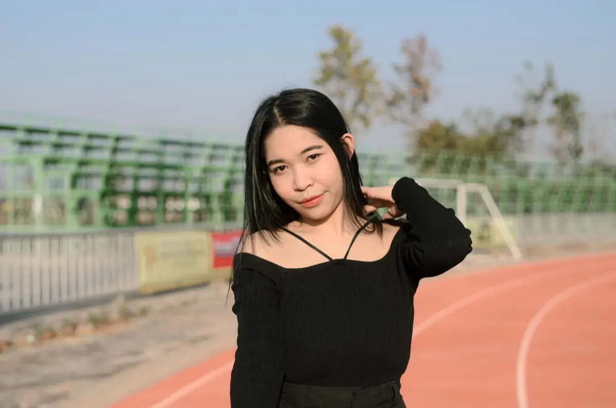 คนโสดยิ้มมั่นใจในชุดลำลองยืนถ่ายภาพบุคคลกลางแจ้ง