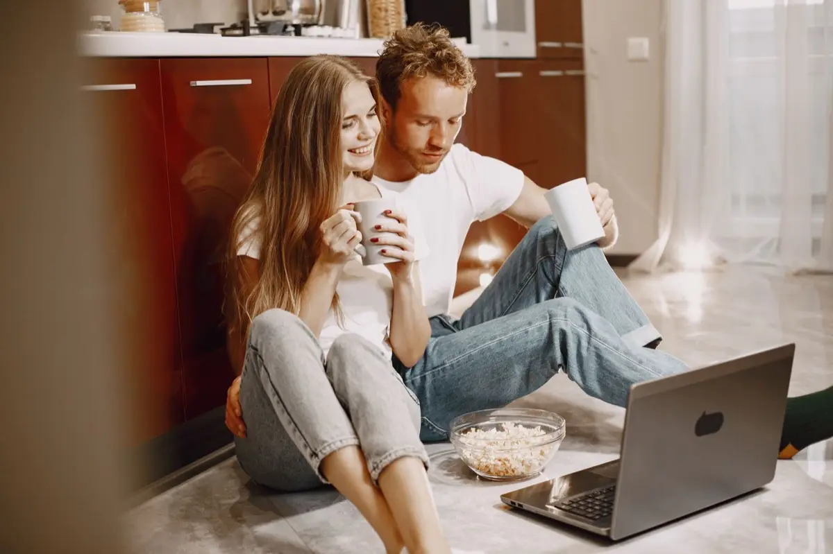 คู่รักนั่งดูหน้าจอสตรีมมิ่งด้วยกันบนโซฟา
