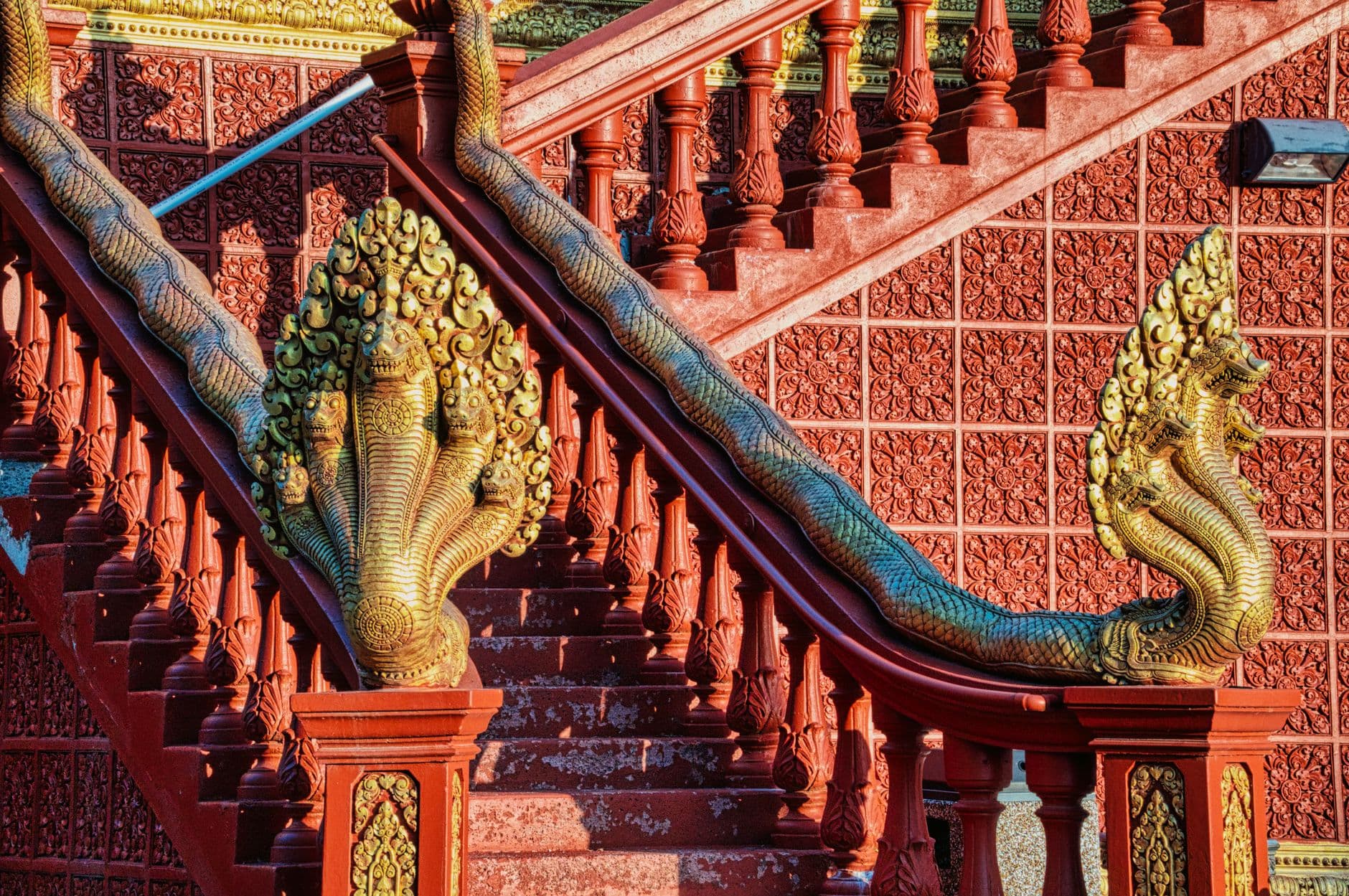 รูปสลักพญานาคสีทองประดับบันไดทางขึ้นวัดไทย
