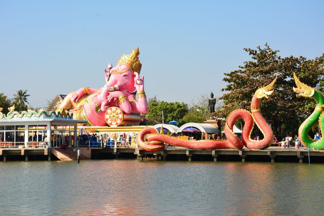 รูปสลักพญานาคสีทองในลานวัดไทยยามบ่าย