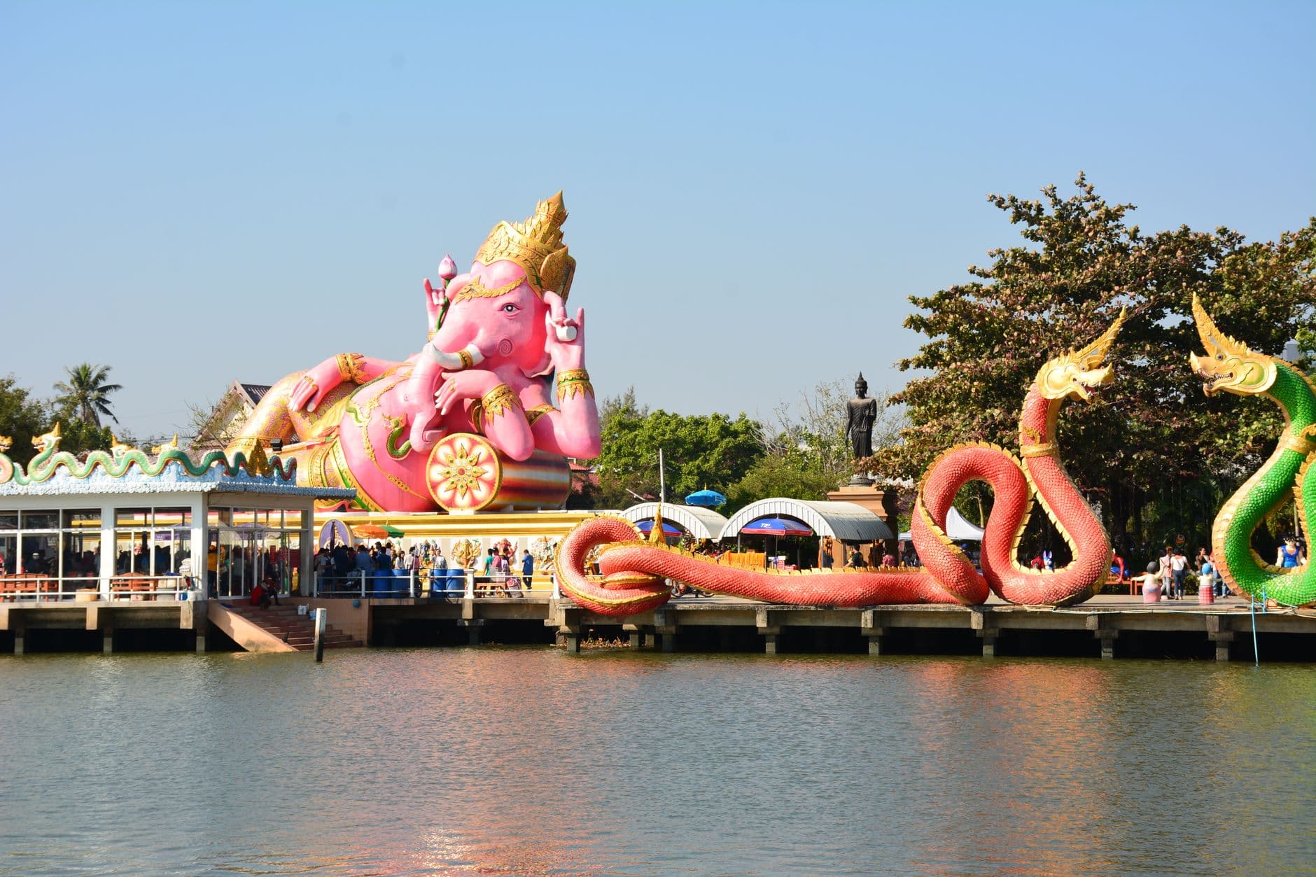 รูปสลักพญานาคสีทองในลานวัดไทยยามบ่าย