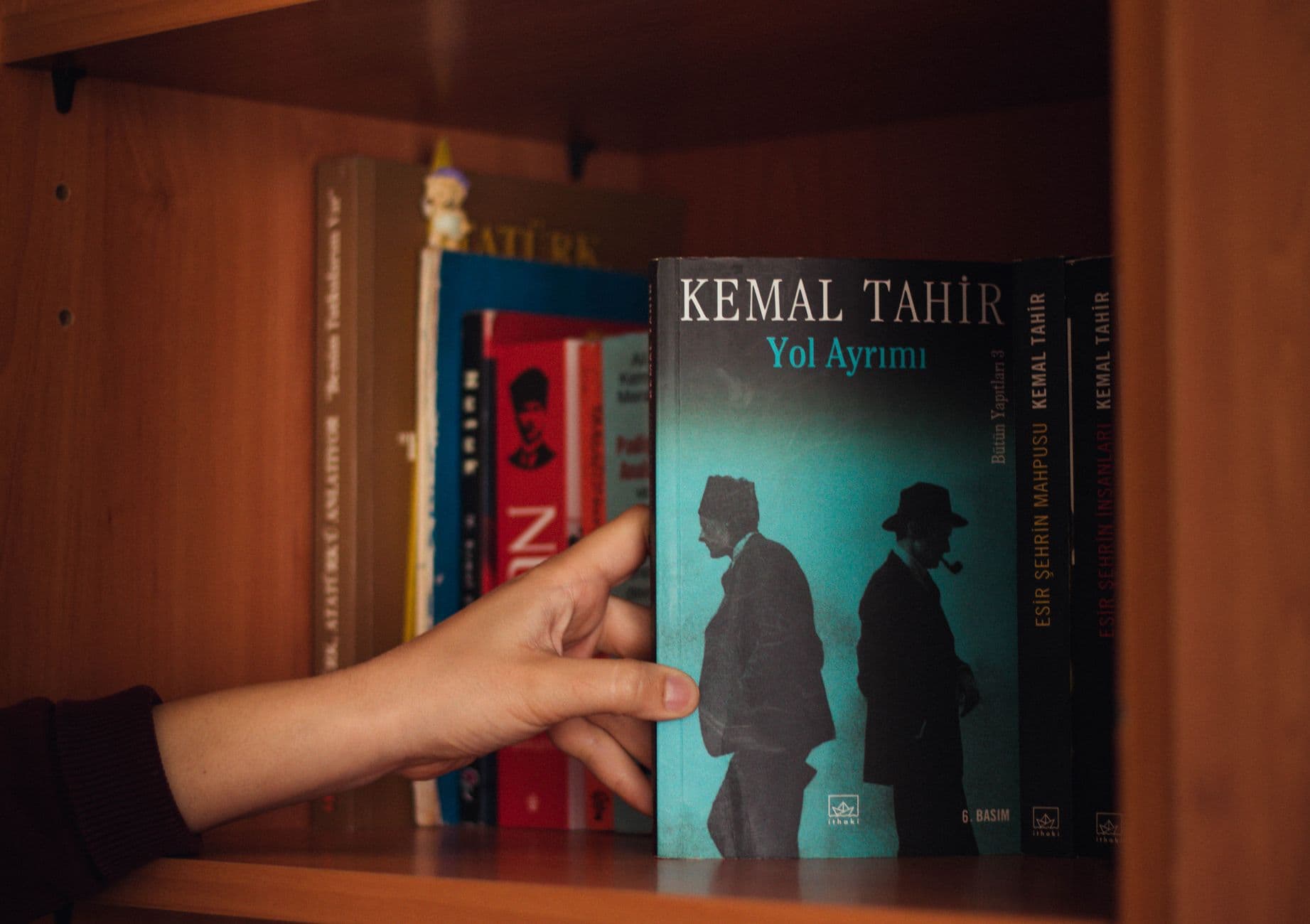 ปกหนังสือหลายเล่มวางเรียงกันบนโต๊ะไม้แสดงการออกแบบชื่อเรื่อง