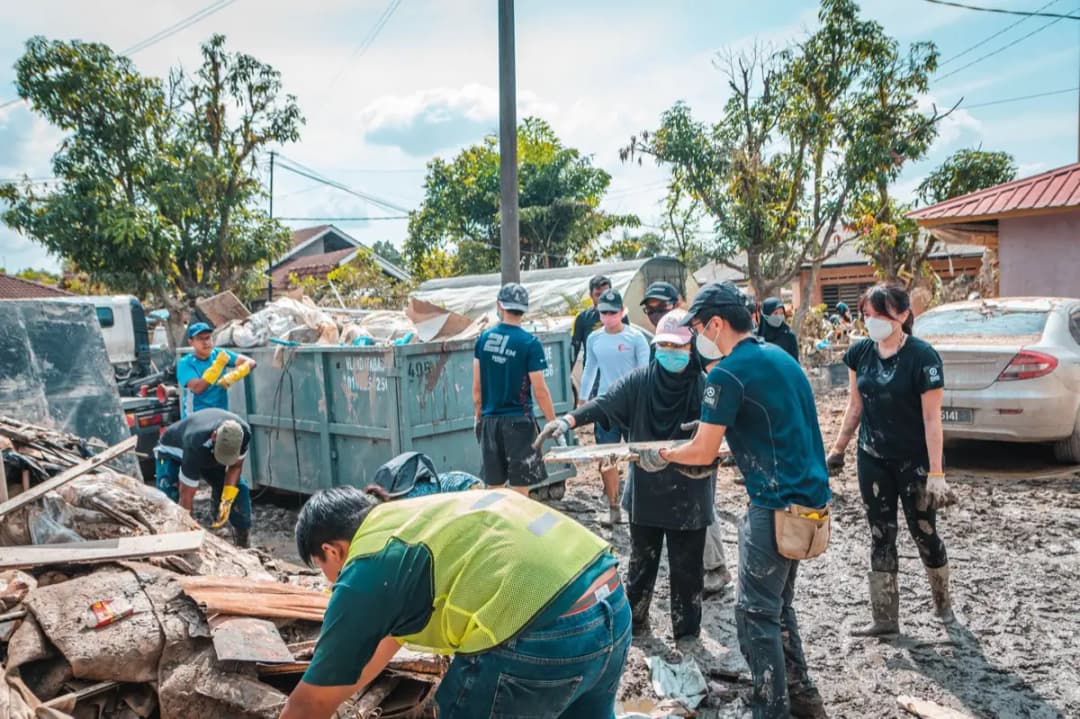 ครอบครัวยืนมองบ้านที่กำลังได้รับการซ่อมแซมฟื้นฟูหลังเกิดความเสียหาย