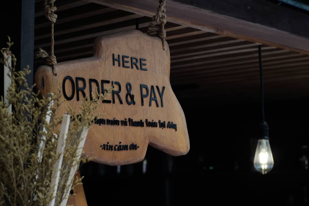 ช่างกำลังติดตั้งป้ายร้านใหม่บนหน้าอาคารพาณิชย์