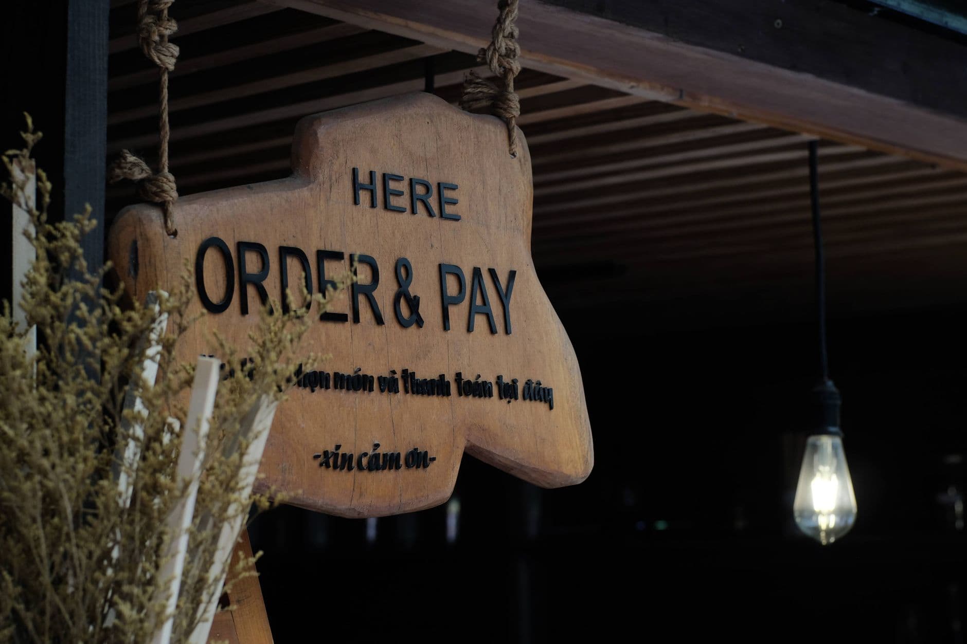 ช่างกำลังติดตั้งป้ายร้านใหม่บนหน้าอาคารพาณิชย์