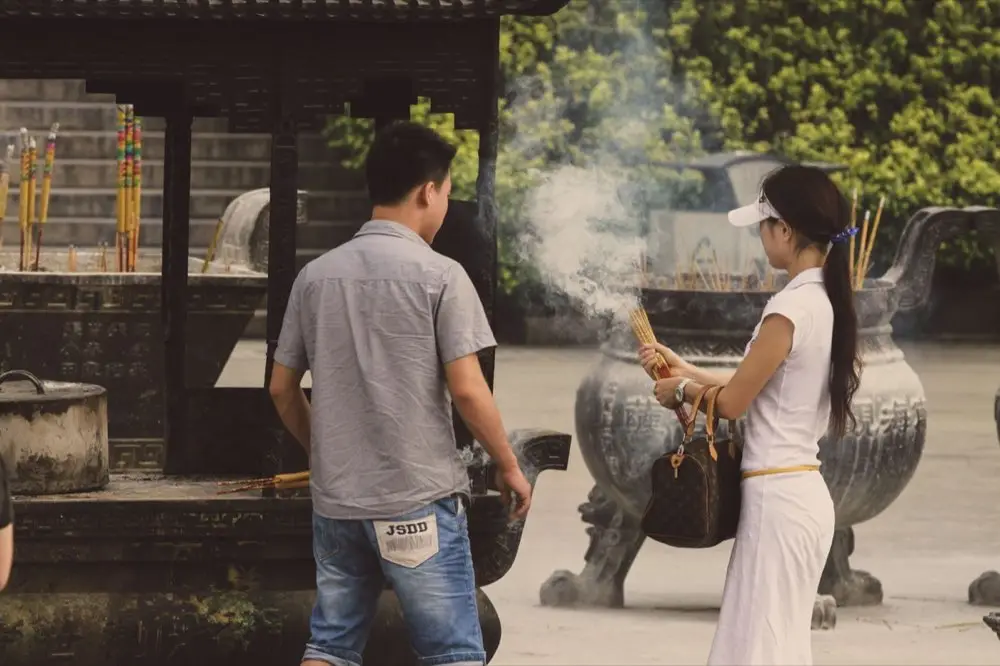 ธูปจุดควันลอยขึ้นในบรรยากาศวัดไทย