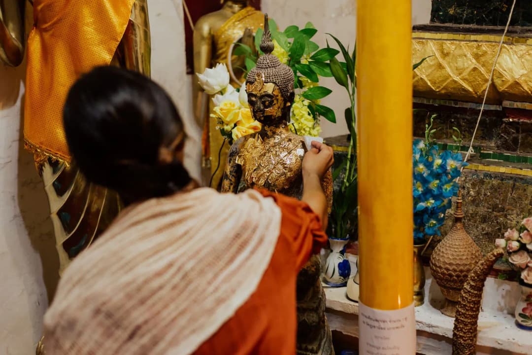 ดอกบัวและดอกไม้สดจัดวางในภาชนะสำหรับถวายไหว้พระที่บ้าน