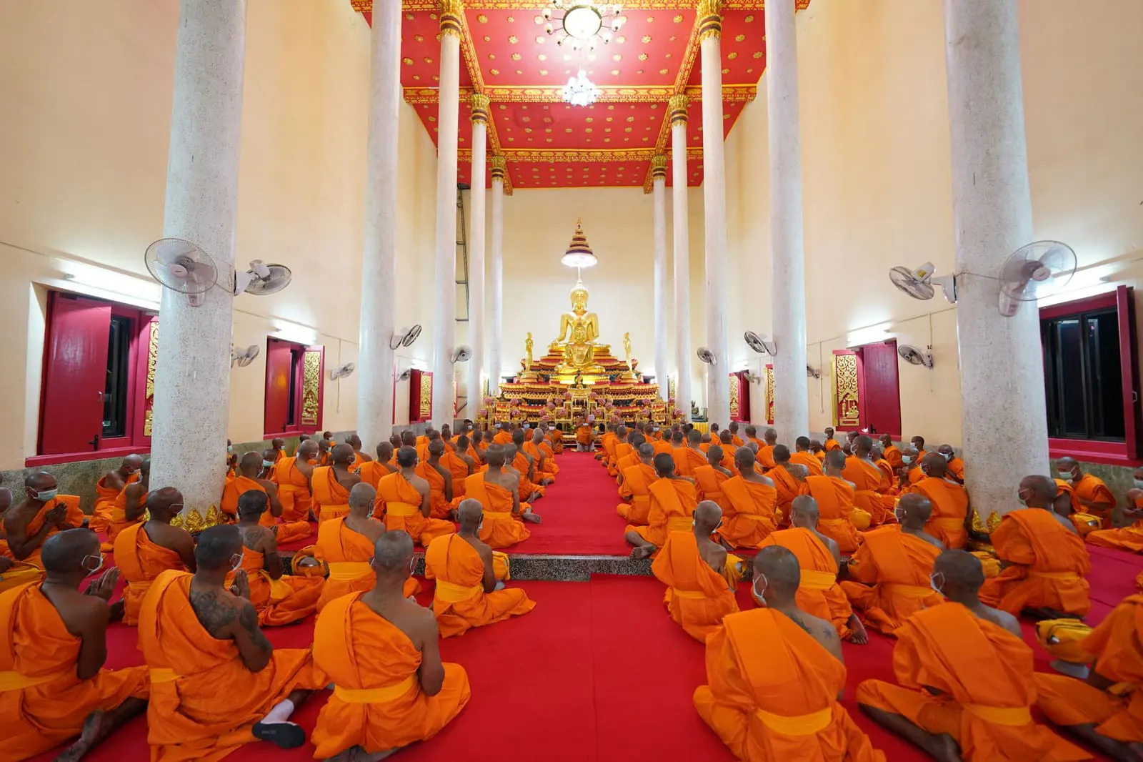 ญาติและคนในครอบครัวช่วยกันเตรียมของสำหรับพิธีบวชนาคที่ลานวัดตอนเช้า