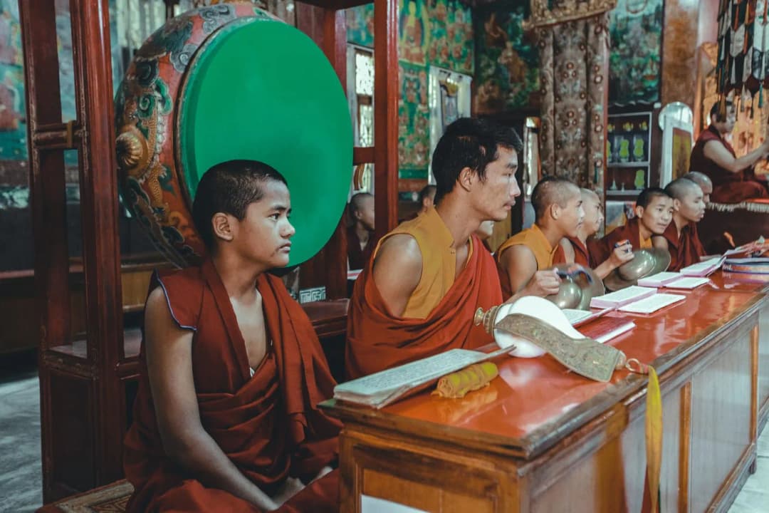 หนังสือสวดมนต์เปิดอยู่บนโต๊ะไม้พร้อมเทียนจุดข้าง ๆ