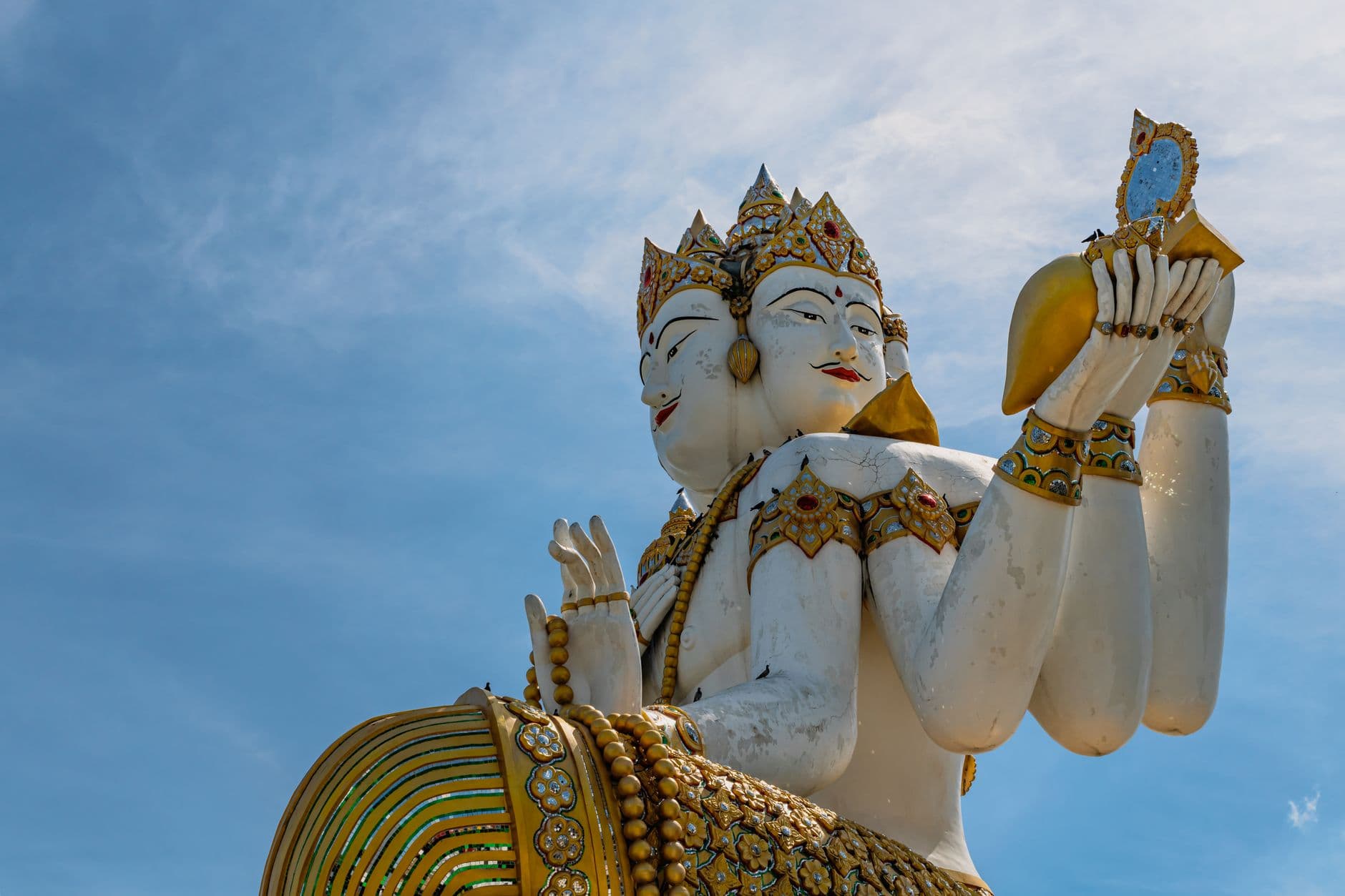 รูปปั้นพระพรหมสี่หน้าประดิษฐานในศาลาที่มีผู้คนมากราบไหว้