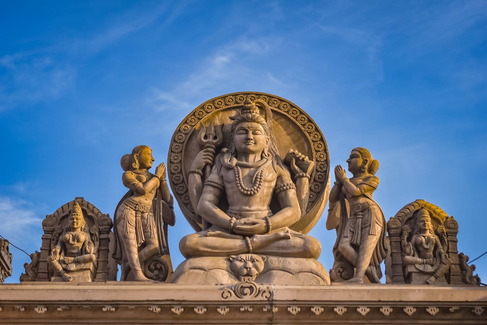 รูปปั้นหินพระศิวะโบราณตั้งอยู่ในเทวสถานที่มีแสงแดดส่องผ่าน