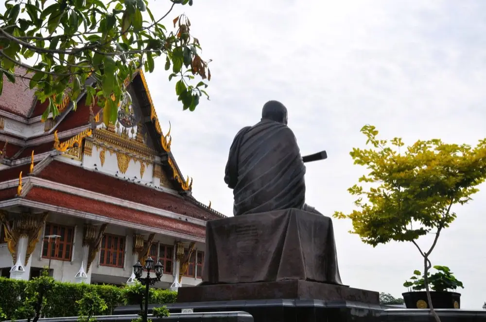 หิ้งบูชาพระสงฆ์ในบ้านมีธูปเทียนและดอกไม้จัดวางเรียบร้อย