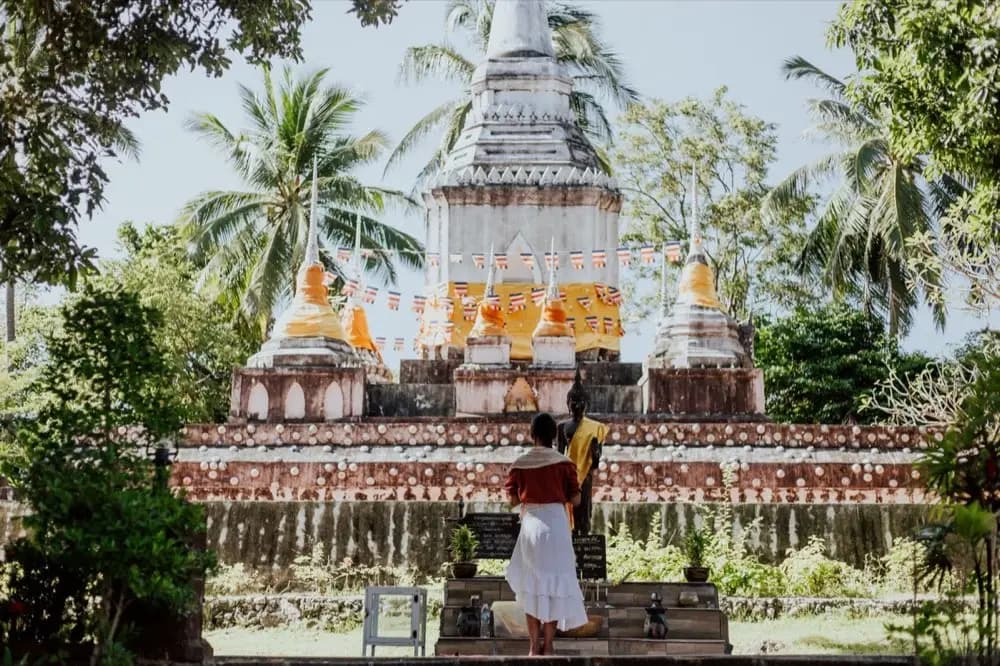 คนกำลังไหว้พระสีวลีที่บ้านเทียบกับบรรยากาศการไหว้ในวัด