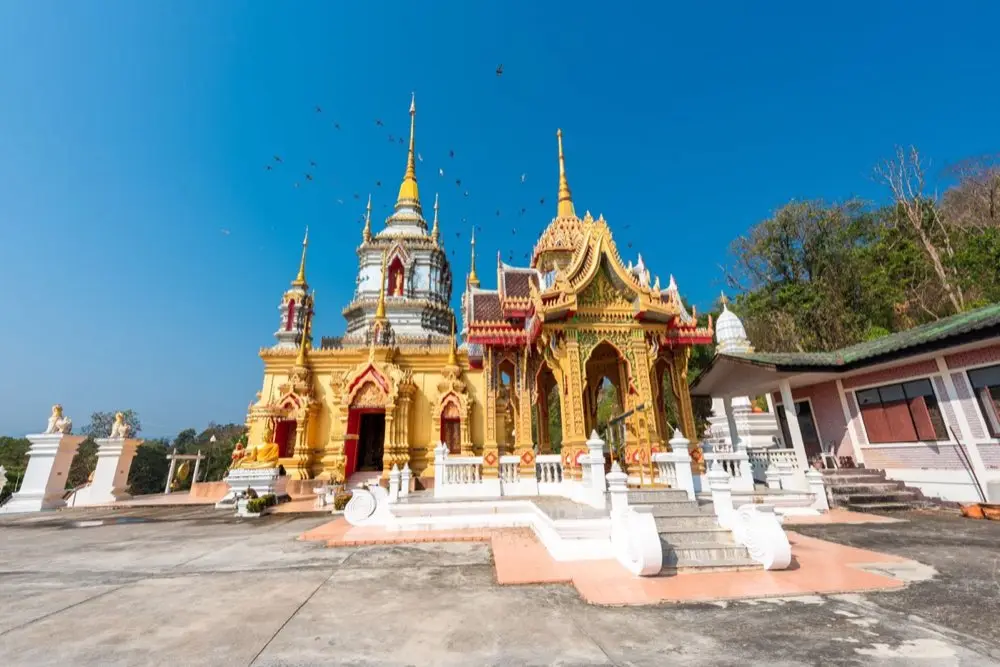 มือกำลังจุดธูปเทียนเตรียมไหว้พระสีวลีที่หิ้งพระในบ้าน