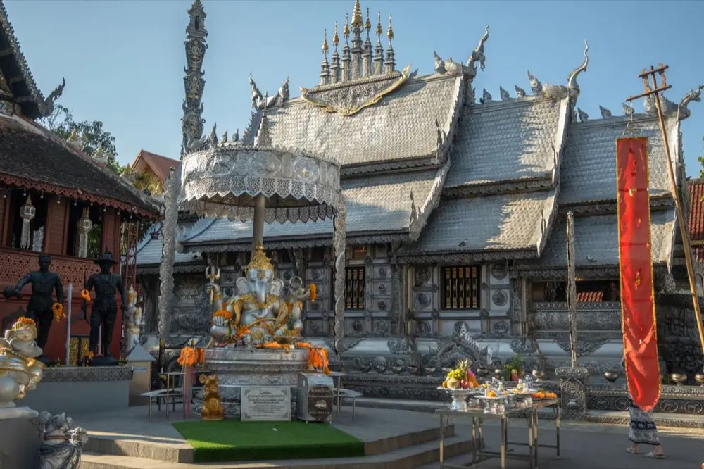 ของไหว้พระสีวลีหลายแบบวางเทียบกันบนโต๊ะ ทั้งผลไม้ ขนมไทย และของแห้ง
