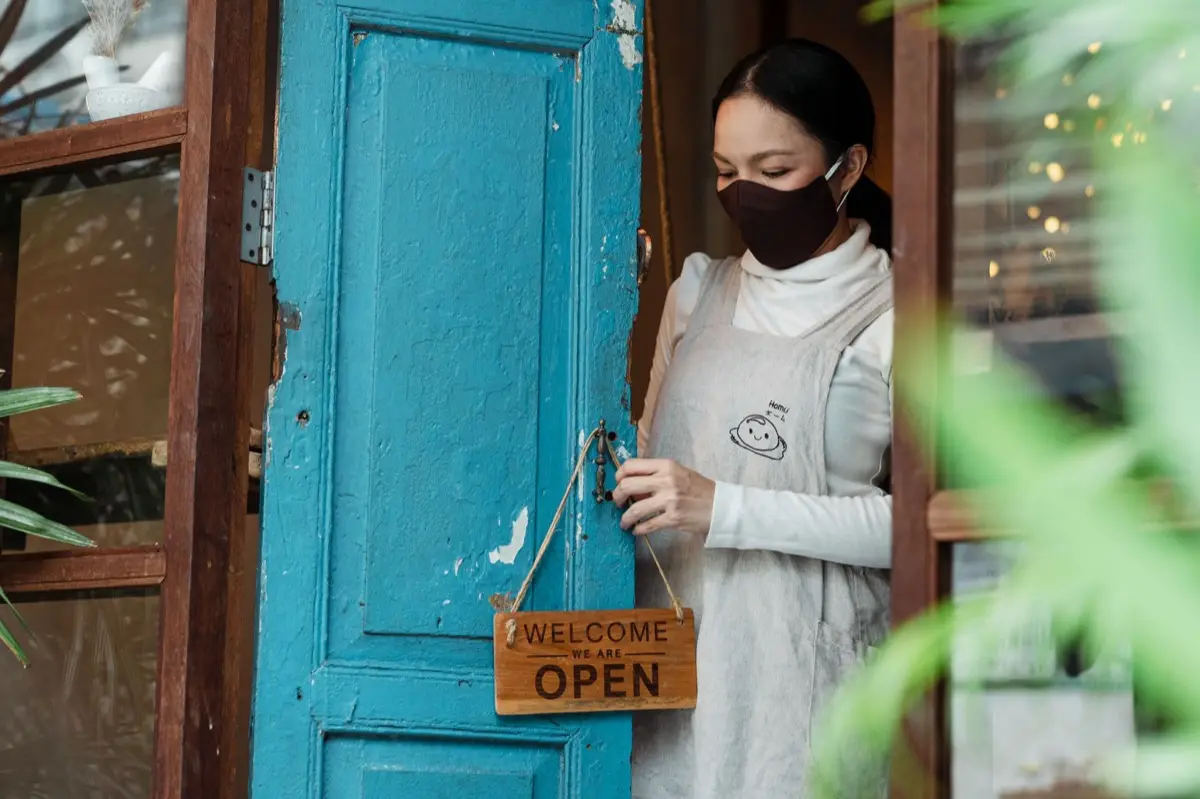เจ้าของร้านกำลังเปลี่ยนป้ายชื่อร้านใหม่หน้าร้านค้า