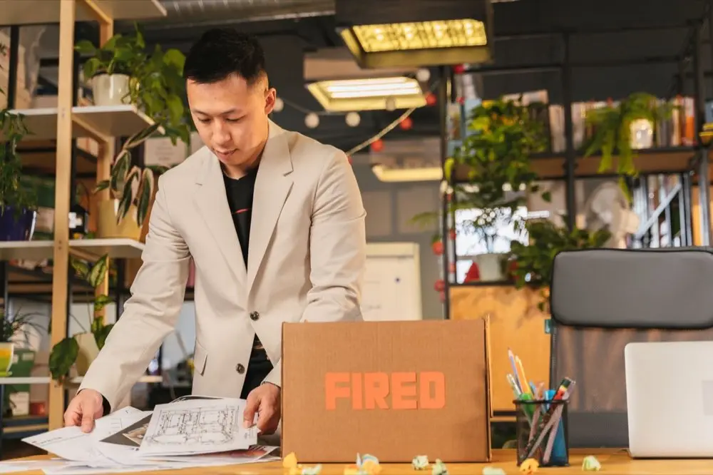 กล่องกระดาษใส่ของใช้ส่วนตัววางอยู่บนโต๊ะทำงานที่ว่างเปล่า