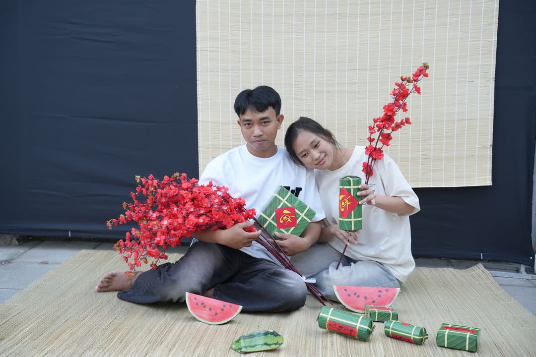 คู่รักยิ้มร่าอยู่ท่ามกลางของตกแต่งปีขาลสีแดงพร้อมเครื่องหมายคำถาม
