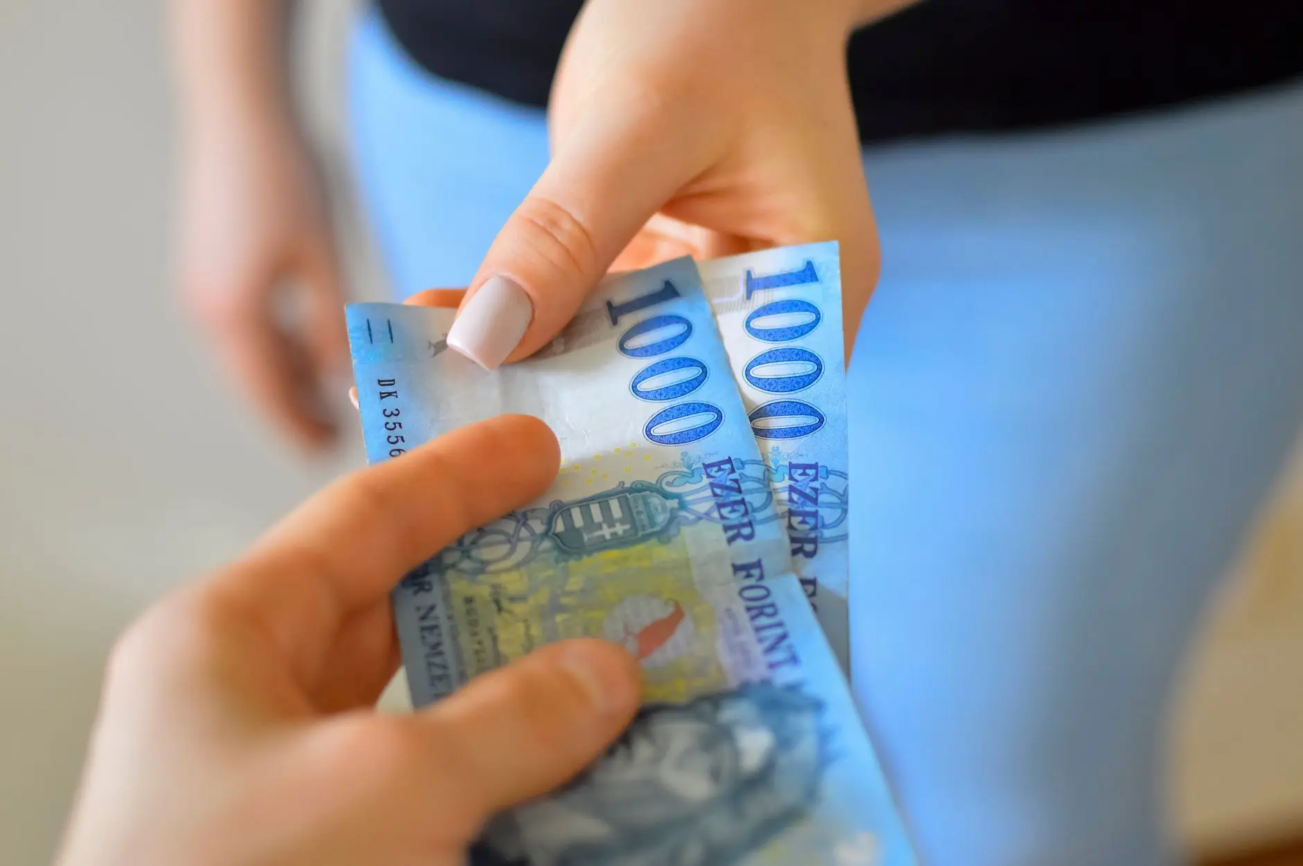 มือถือธนบัตรและกดโอนเงินผ่านแอปธนาคารบนมือถือ