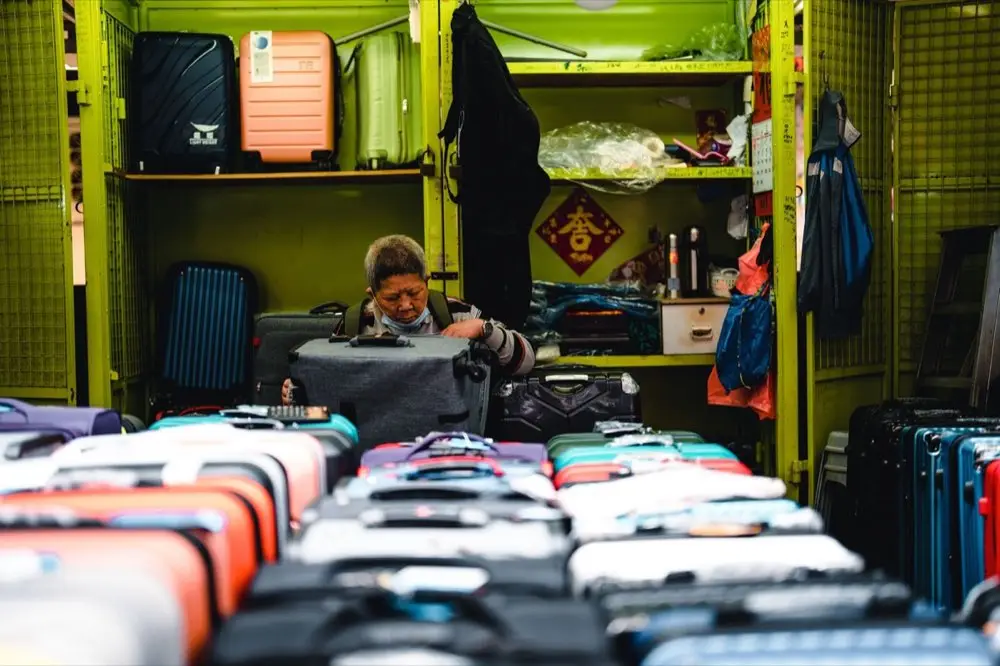คนกำลังเลือกดูกระเป๋าเดินทางหลายใบในร้านขายกระเป๋าเดินทาง