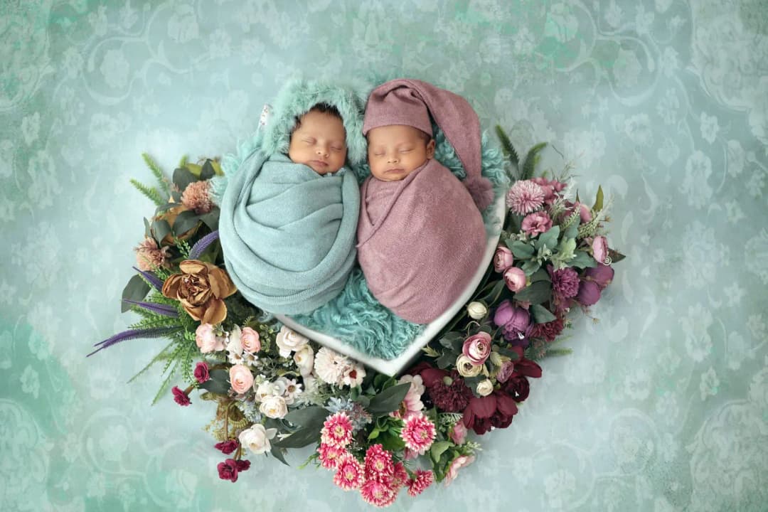 ทารกแฝดสองคนนอนหลับเคียงกันบนผ้าห่มสีอ่อน