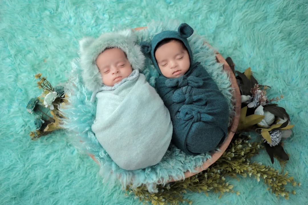 เปลเด็กแฝดสองเปลวางเรียงกันในห้องนอนเด็กตกแต่งโทนสีอ่อน