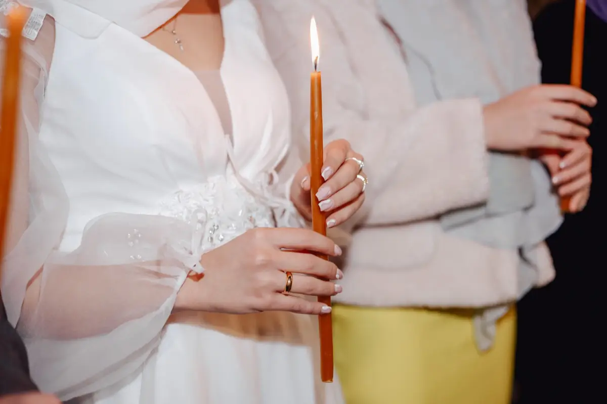 มือคู่บ่าวสาวจุดเทียนชัยร่วมกันในพิธีมงคลสมรส