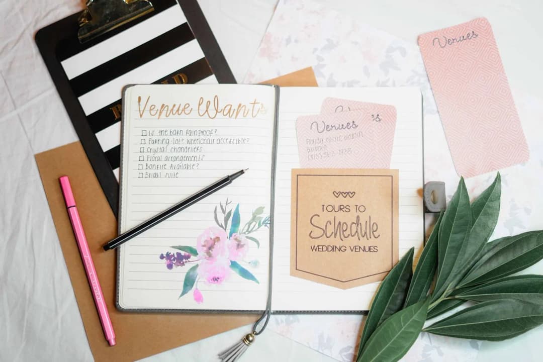 คู่รักดูปฏิทินและจดวันที่พร้อมโทรศัพท์อยู่ข้างกันบนโต๊ะ