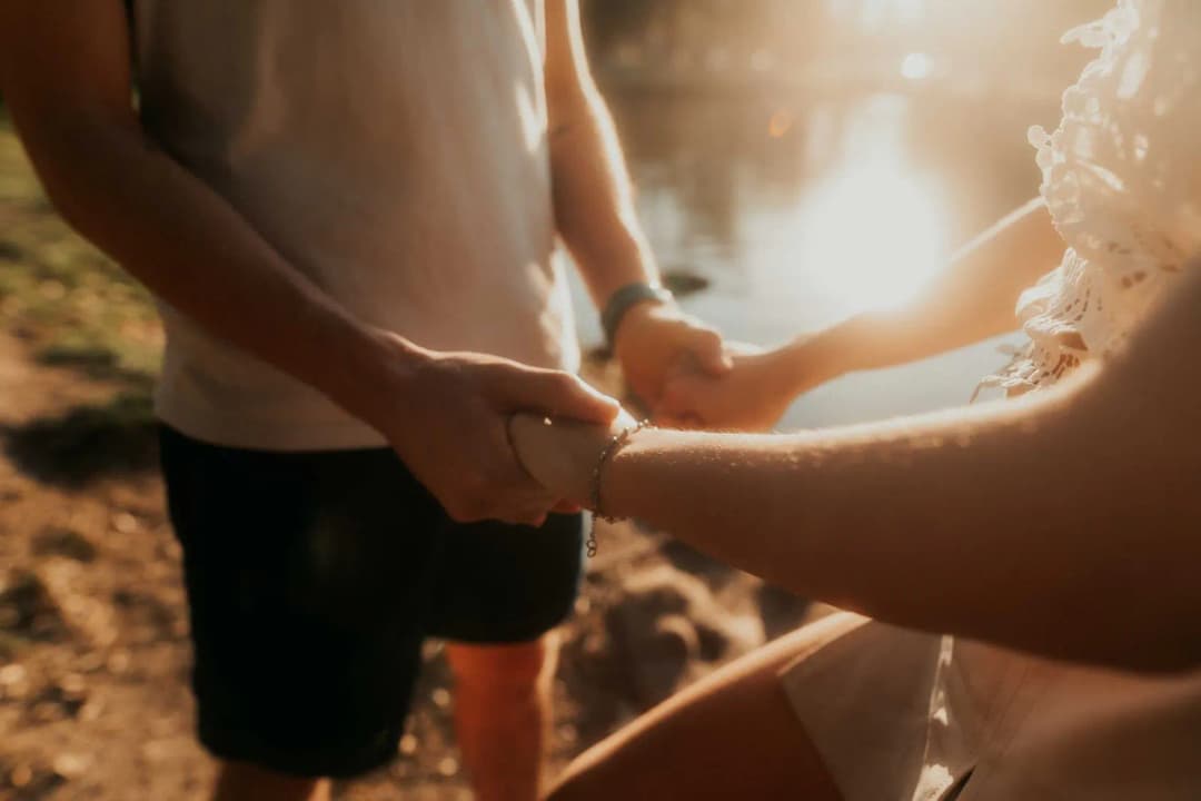 คู่รักจับมือกันในแสงอาทิตย์ยามเย็นอบอุ่น